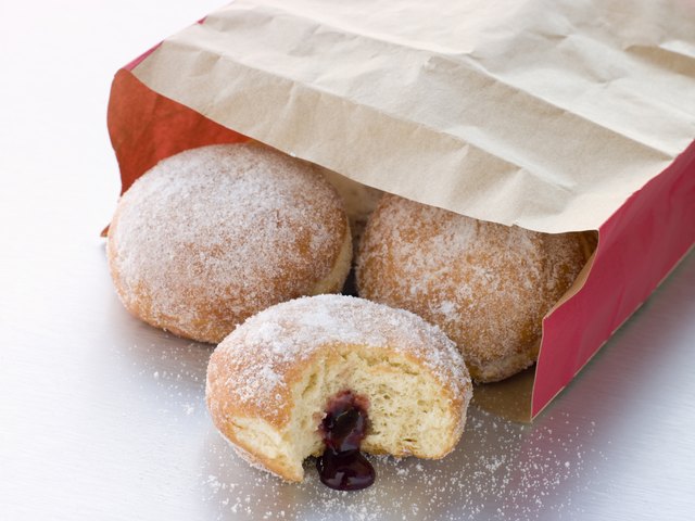 Bag Of Raspberry Jam Doughnuts With A Bite Taken