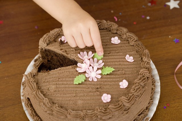 Hand touching cake