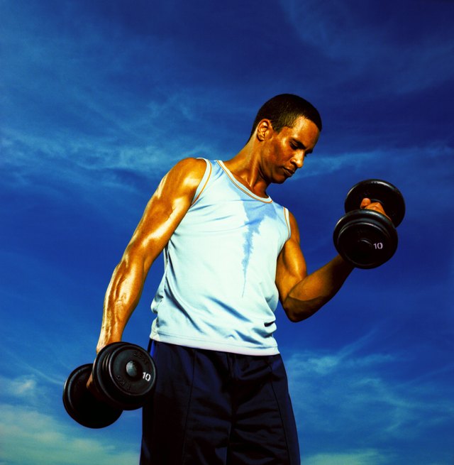 Low angle view of a young man exercising with dumbbells