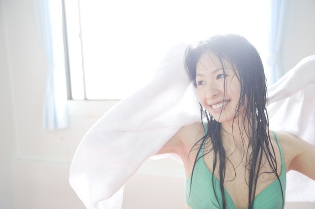 A Young Woman Drying Her Hair With A Towel