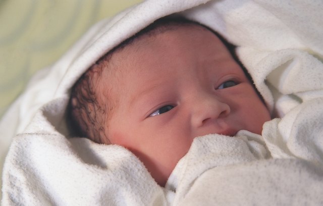 Newborn wrapped in white blanket