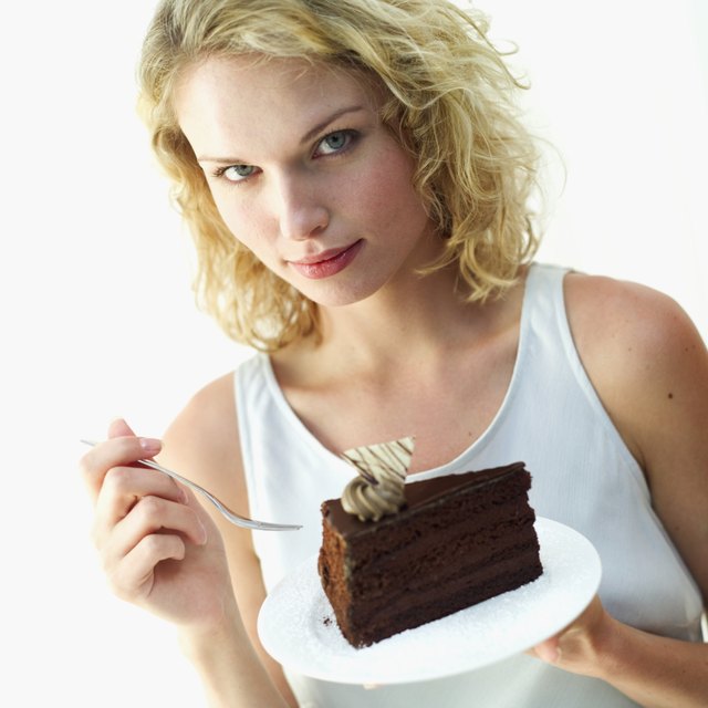 Portrait of a young woman holding a piece of chocolate cake on a plate
