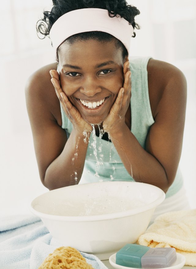 Woman Bending Over to Wash Her Face in a Bowl