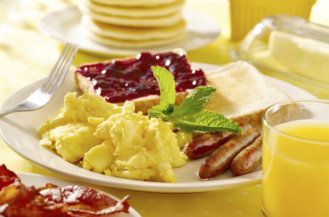 breakfast with scrambled eggs, sausage links and toast.