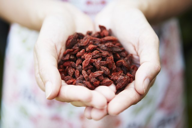Woman Holding Handful Of Goji Berries