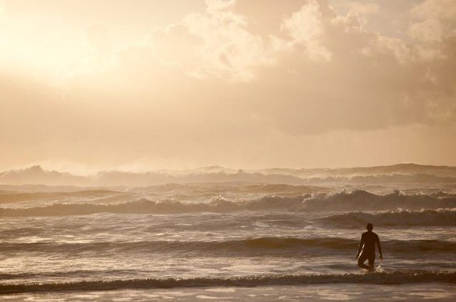Surfer and waves at sunset