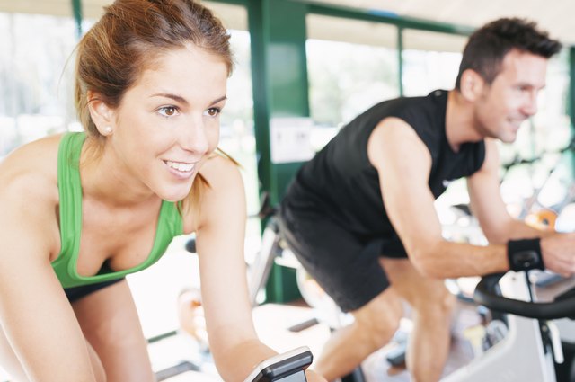 Athletes using the stationary bicycle in a gym