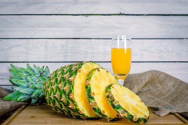 Pineapple and juice on a wooden board