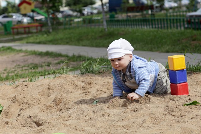 Child creeping in sandbox