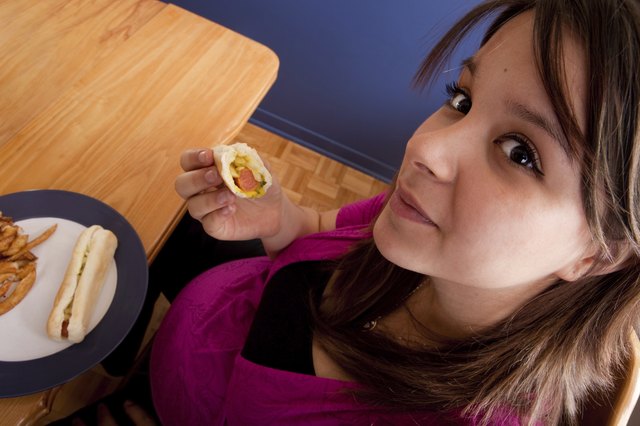 Young pregnant woman eating junk food