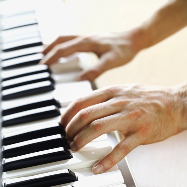 Man playing a keyboard close-up of hands