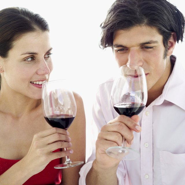 close-up of a couple smelling the aroma of red wine