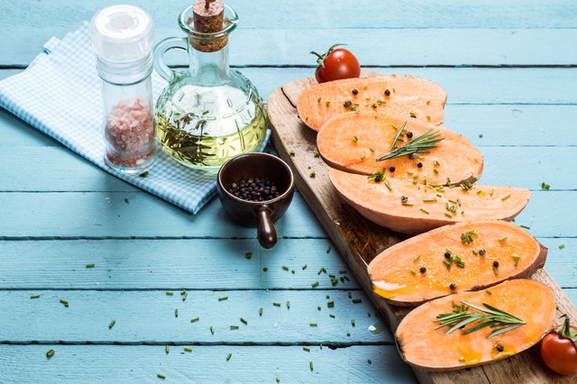 Raw sweet potatoes slice on wooden background closeup