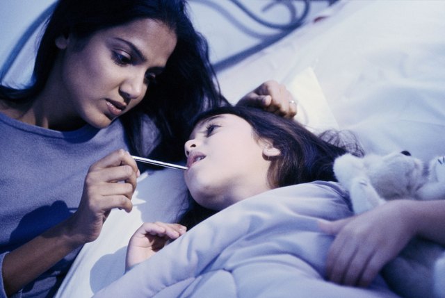 portrait of mother taking daughters temperature