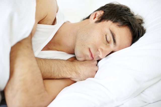 Handsome young guy sleeping in bed
