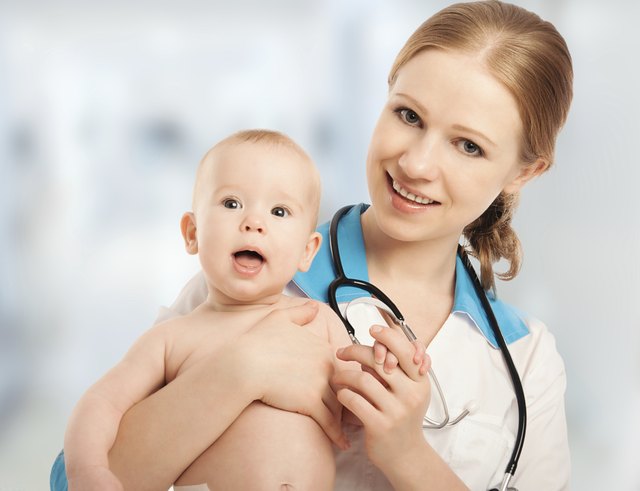 Pediatrician woman doctor holding patient baby