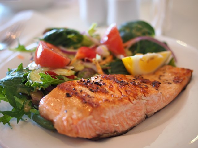 Plate of broiled salmon with asparagus and salad
