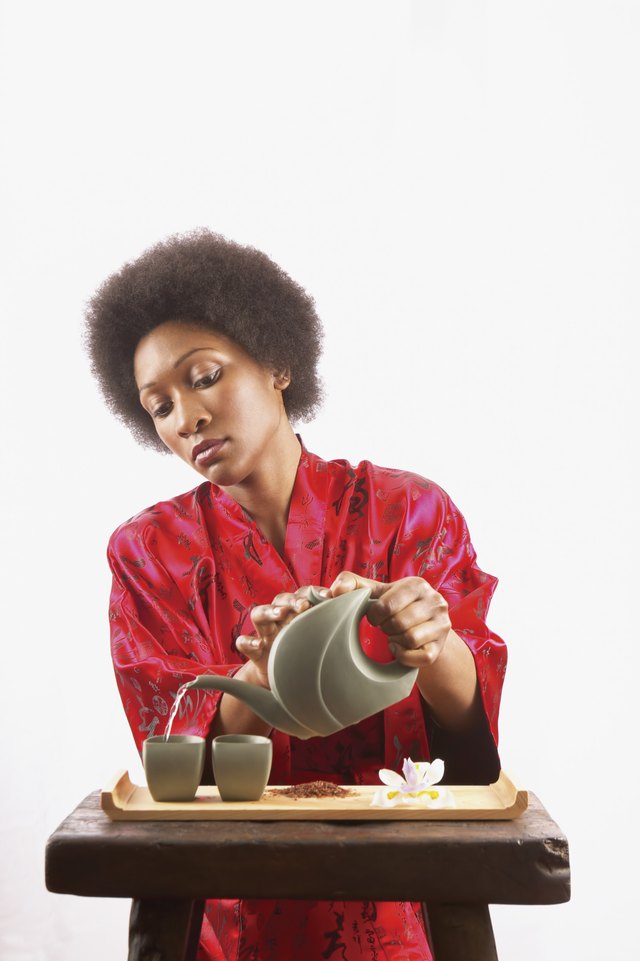 Young woman pouring green tea