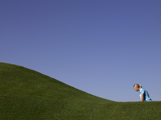 Woman playing golf, side view