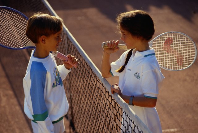 Children (6-9) face to face on tennis court