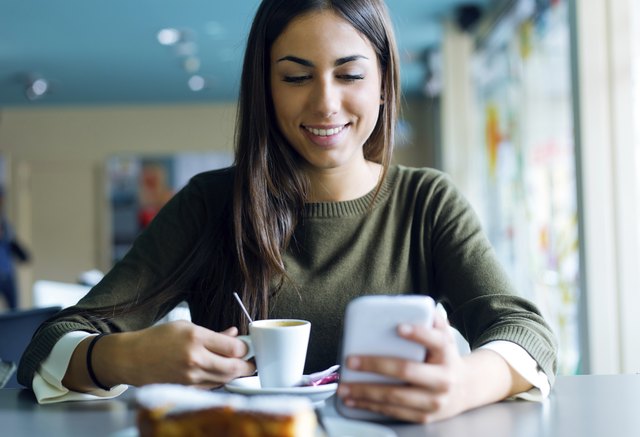 Beautiful girl using her mobile phone in cafe.