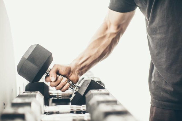 Unrecognizable man taking dumbbells in a gym