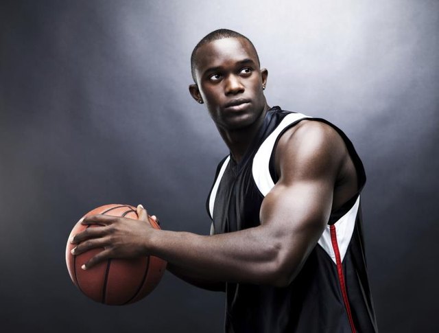 Muscular, young afro-american man playing basketball