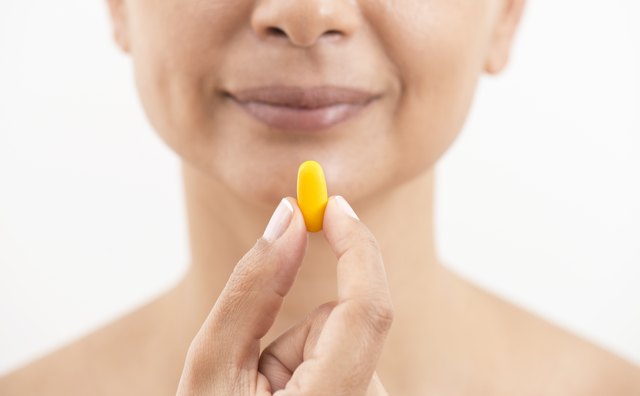 Woman Holding And Showing Yellow Pill