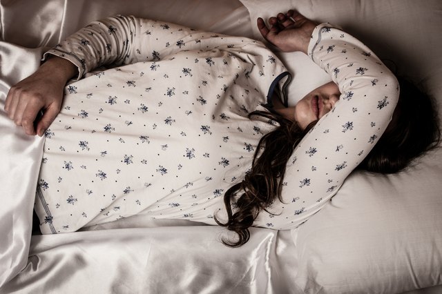 woman lying in bed with flu and fever feeling sick