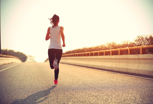 young fitness woman trail runner running on city road