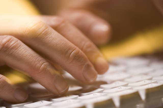 Close-up of person typing on a computer keyboard