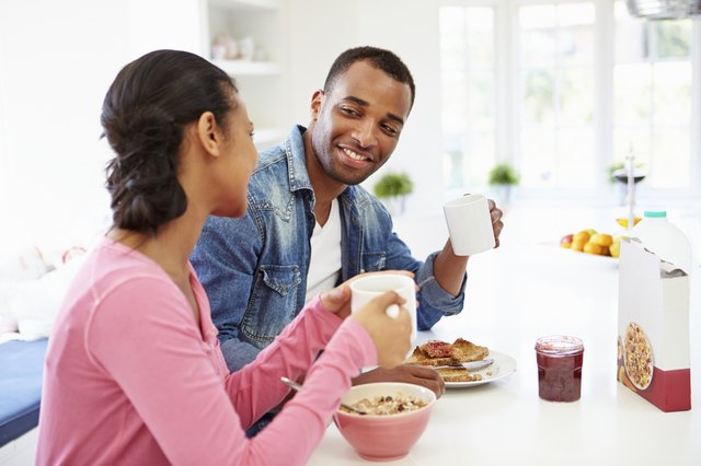 Couple Having Breakfast In Kitchen Together