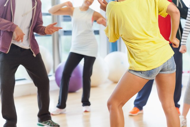 Low section of fitness class and instructor doing pilates exercise