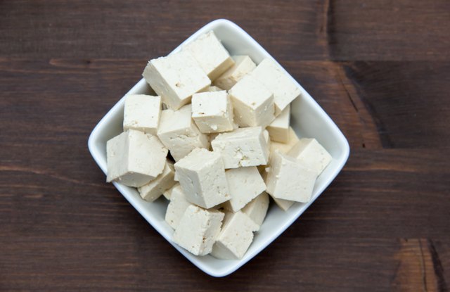 Tofu cubes on wooden square bowl on top