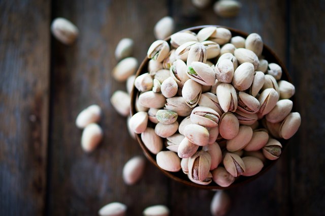 Close-up of roasted pistachios on wooden background