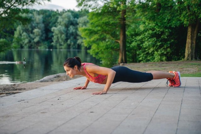 fitness girl doing pushups in park