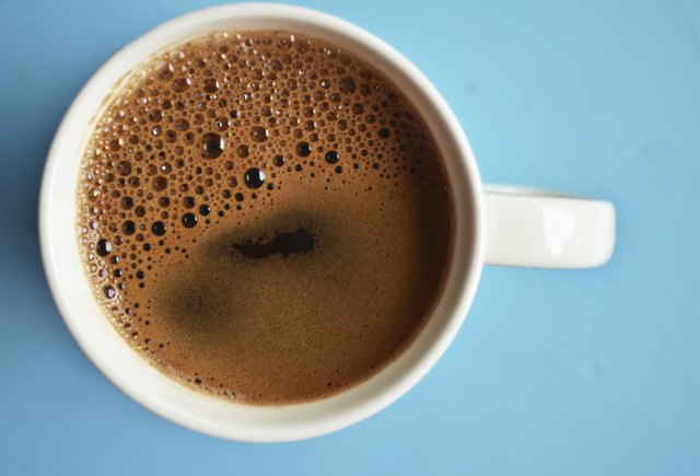 Cup of black coffee on blue background