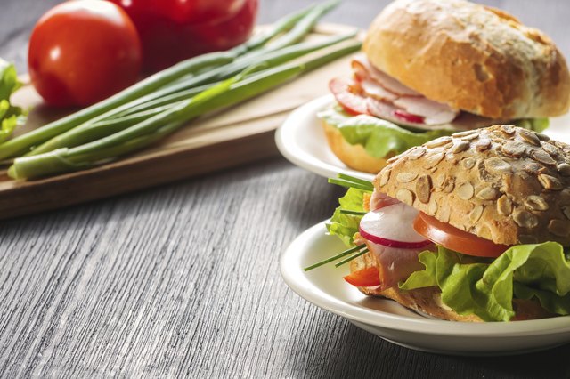 Fresh ham sandwich on wooden board - close up