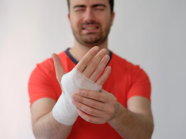 sport man with bandages medication on his hand suffering after a sport injury