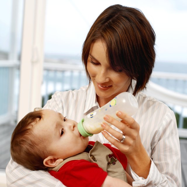 mother bottle feeding baby son (6-12 months)