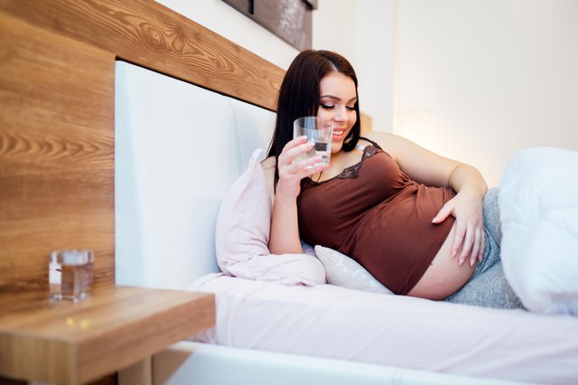 Beautiful pregnant woman drinking water