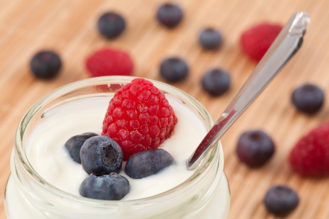 Close up of a pot yoghurt with blueberries and raspberry