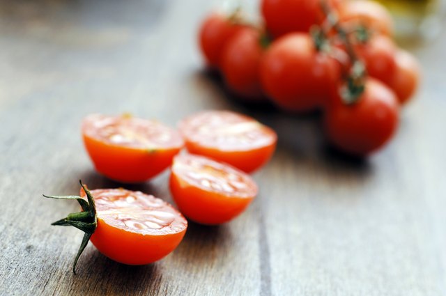 mini sliced halved cherry tomatoes against oak background