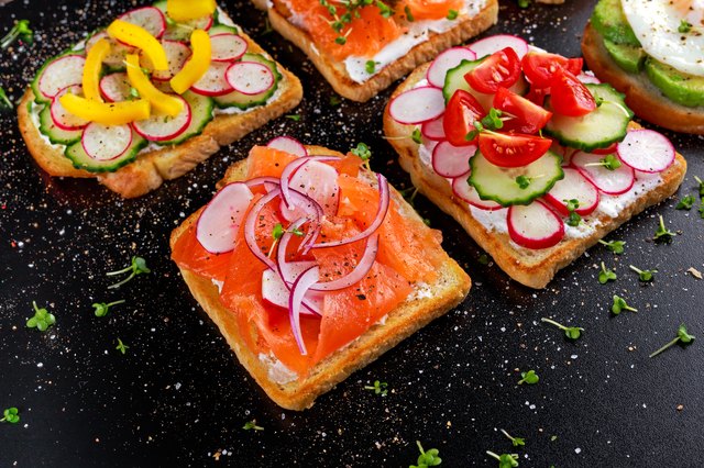 Variety of vegetarian toast sandwiches with salmon, raddish, tomatoes, cucumber