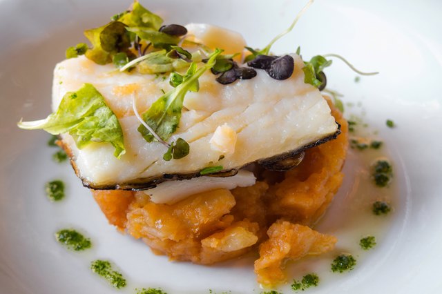 baked cod on a bed of potatoes