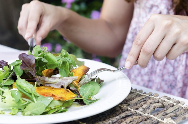 Woman hands and green salad during a meal