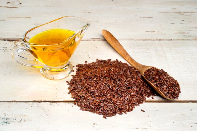 brown flax seed and linseed oil, on wooden table