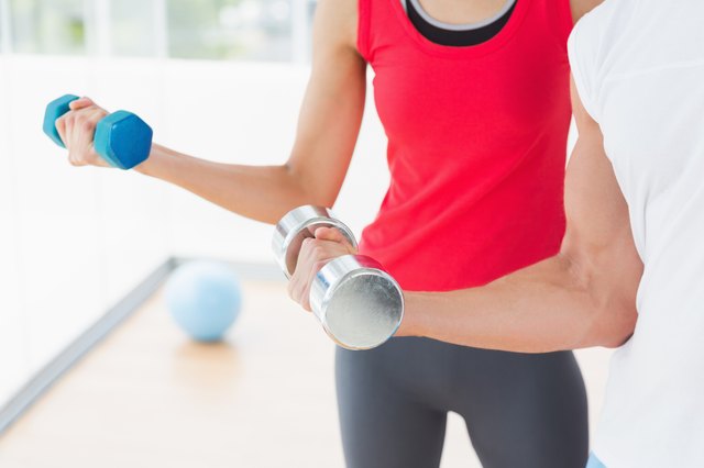 Mid section of a sporty couple with dumbbells