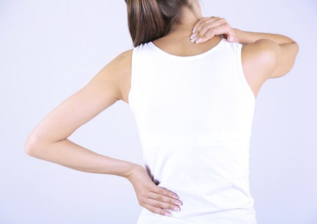 Young girl and pain in neck gray background