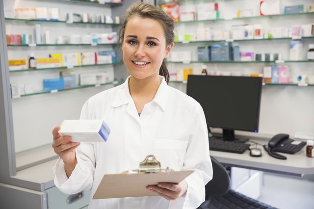 Junior pharmacist holding medicine box